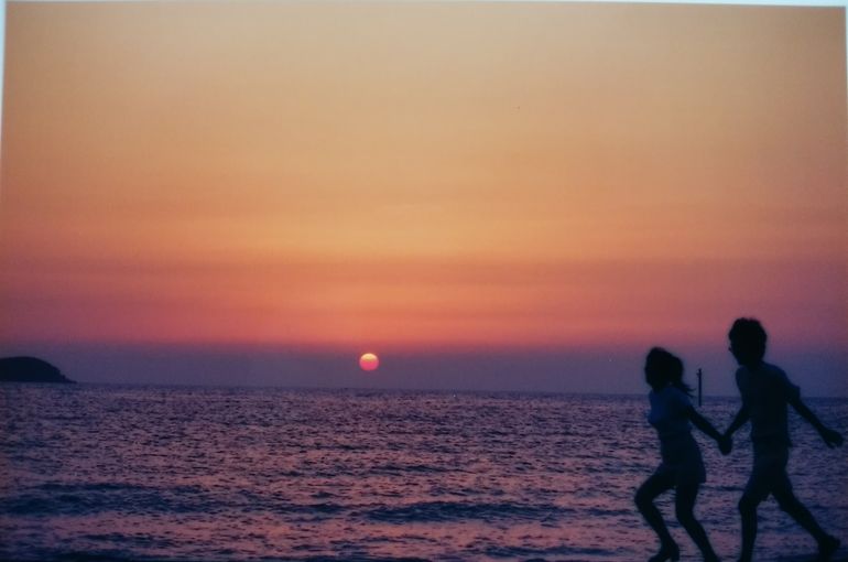 夕焼け空をバックに 二人が走っている。