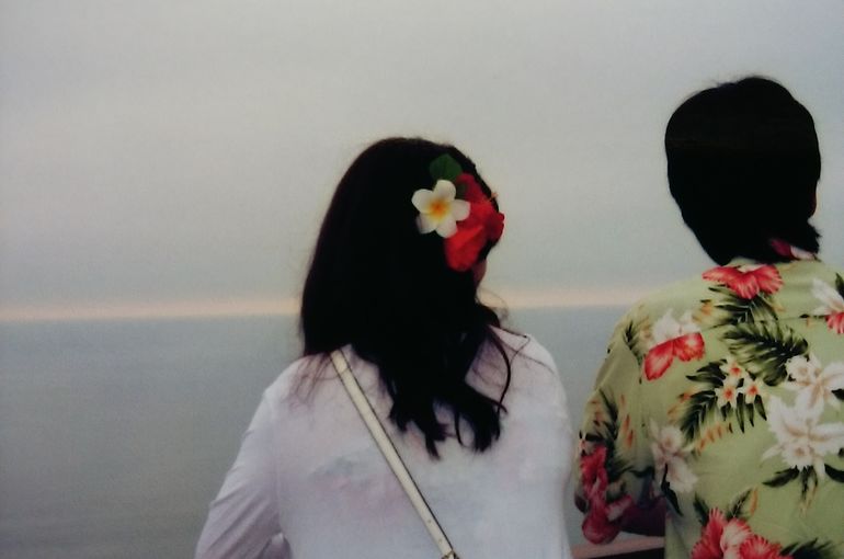 展望台から海を見下ろす二人の後ろ姿