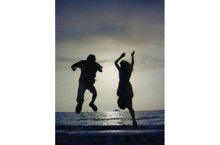 逆光なので、夕日に向かってジャンプする二人が黒く写っている。