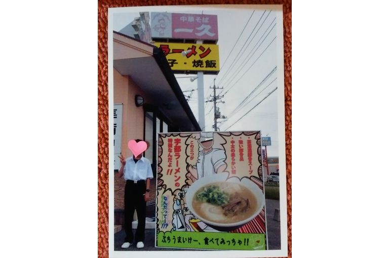 顔ハメ看板の隣でVサインをしている息子