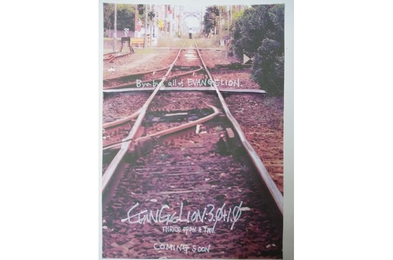 遠くまでまっすぐ伸びた線路の真ん中に小さく見える夏の学生服の少年