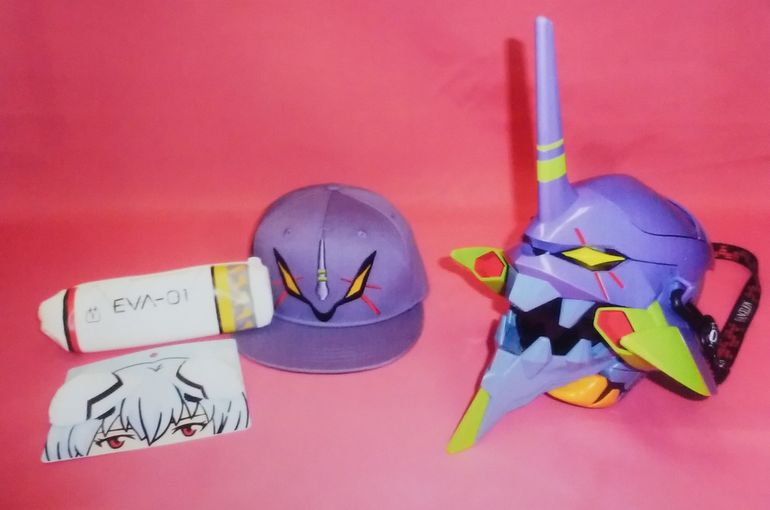 初号機の顔が描かれた紫色のキャップ・ポップコーンバケツ・綾波レイの白いインターフェイス(髪飾り)とエントリープラグ(操縦席)の筆箱・