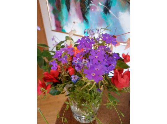 花瓶の中の赤紫色の小花と赤い花