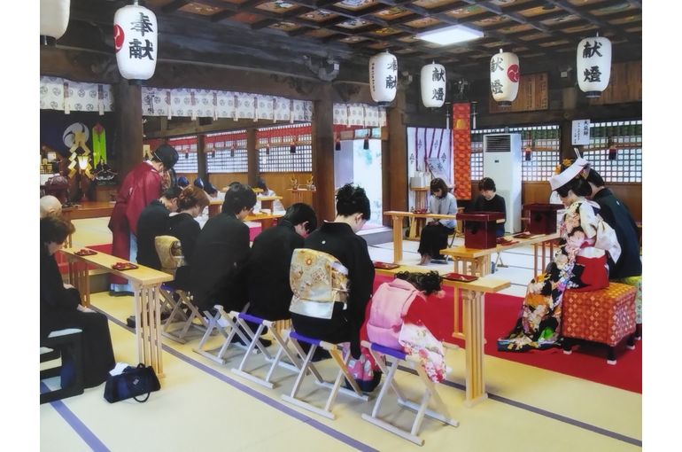 式の様子。新郎新婦は正面に向かって、親族は左右に分かれて向かい合わせに席に付いている。