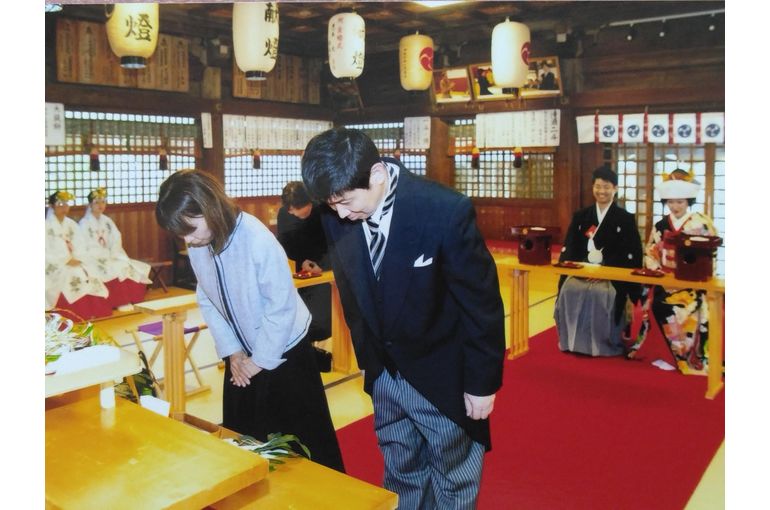 両家代表が榊を奉納しお辞儀をしている
