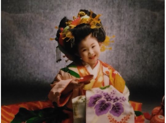 花魁姿の4歳の女の子が盃を持ってニッコリしている(半身)