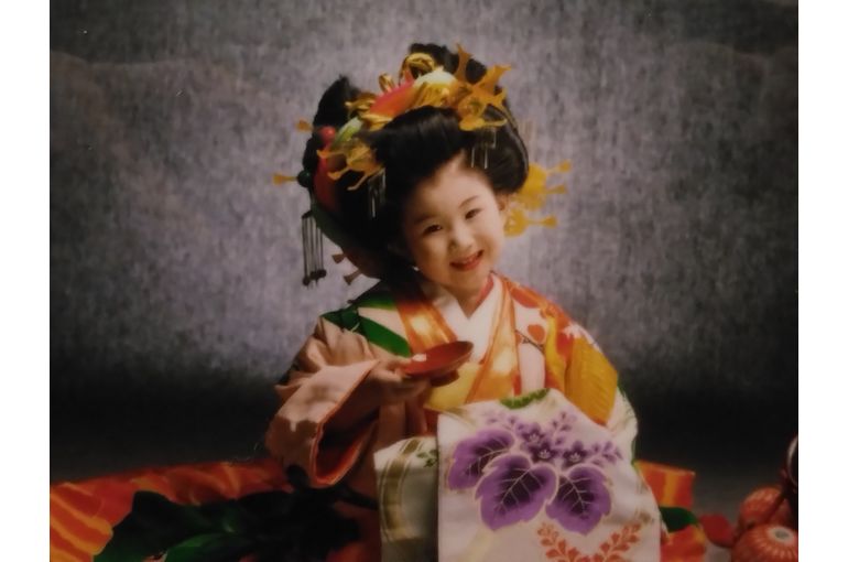 花魁姿の4歳の女の子が盃を持ってニッコリしている(半身)