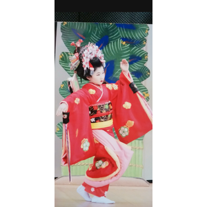 赤い着物、豪華な髪飾りの女の子がステージで踊っている