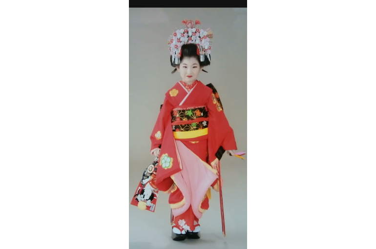 黒いぽっくり下駄を履いてポーズをとっている